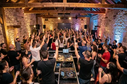 Vue grand angle d'une soirée DJ animée en Gironde avec une foule dansante et une scène équipée de platines dans une salle au style bordelais